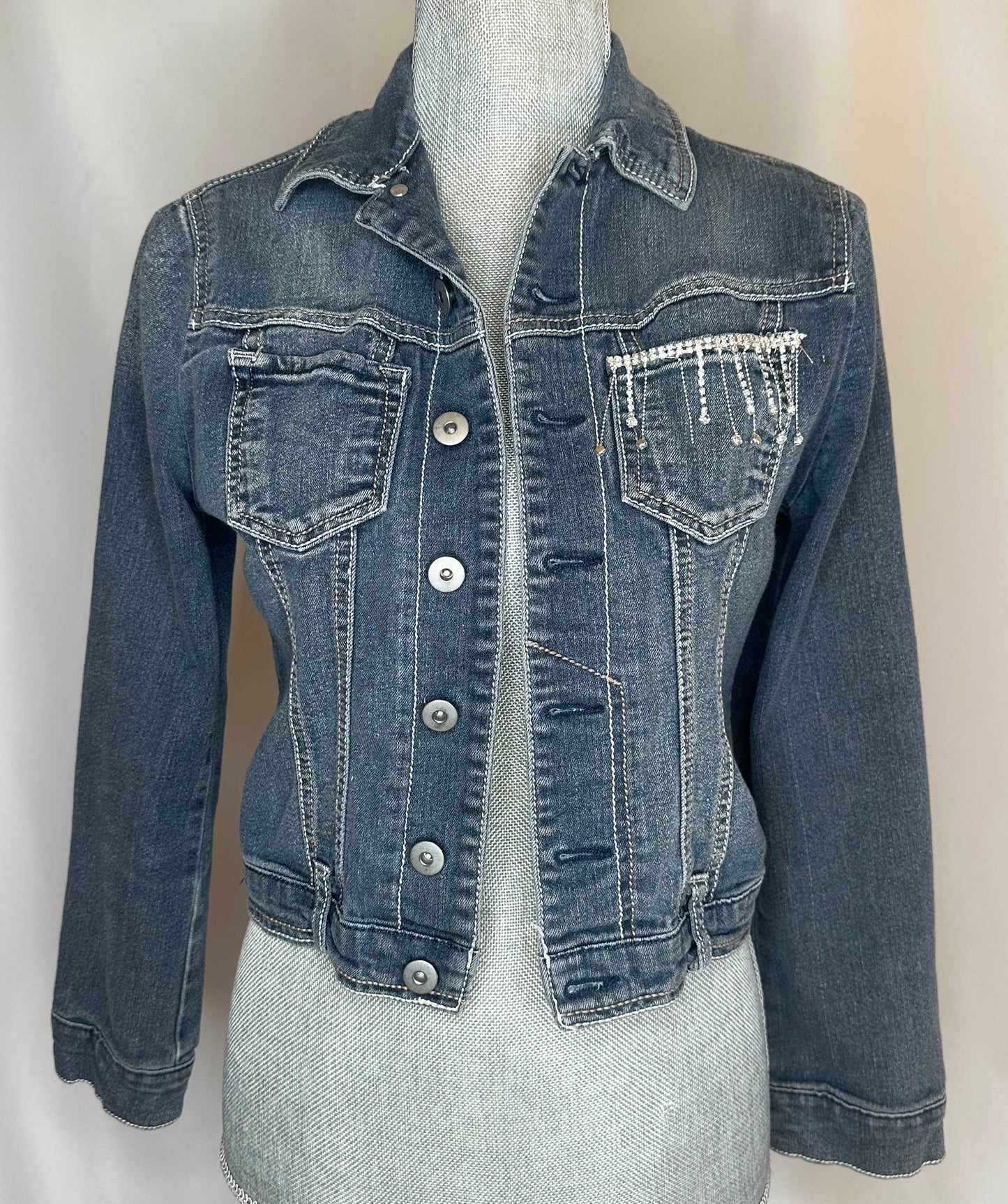 Black Fringe "Cowboys & Tequila" Denim Jacket Front Side, featuring rhinestone waterfall detailing on left pocket and stitching detail.