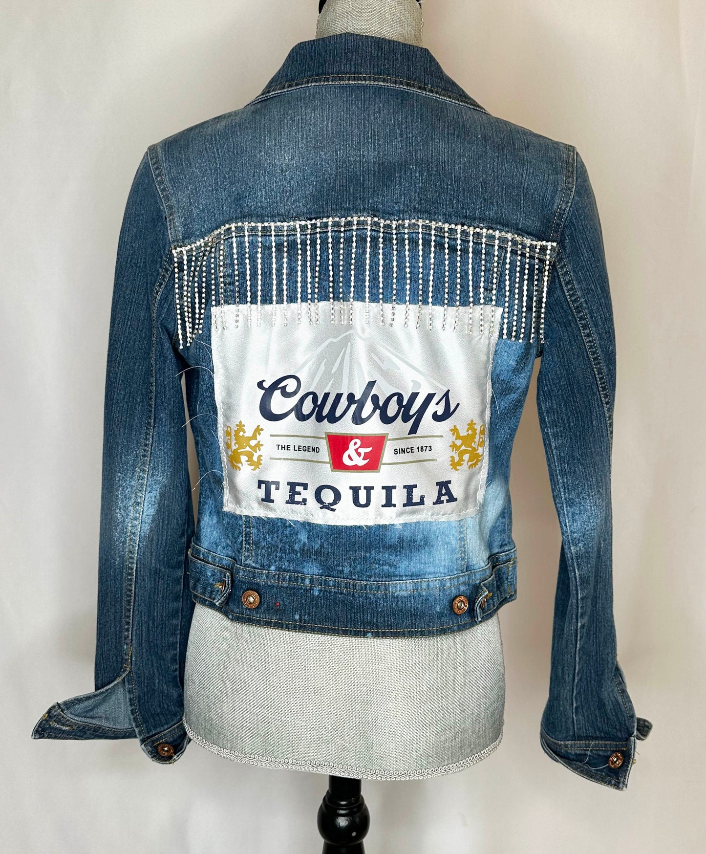 "Cowboys & Tequila" Womens Denim Jacket Back Side with rhinestone detailing and satin patch. Double button detailing at the bottom and on cuffs.