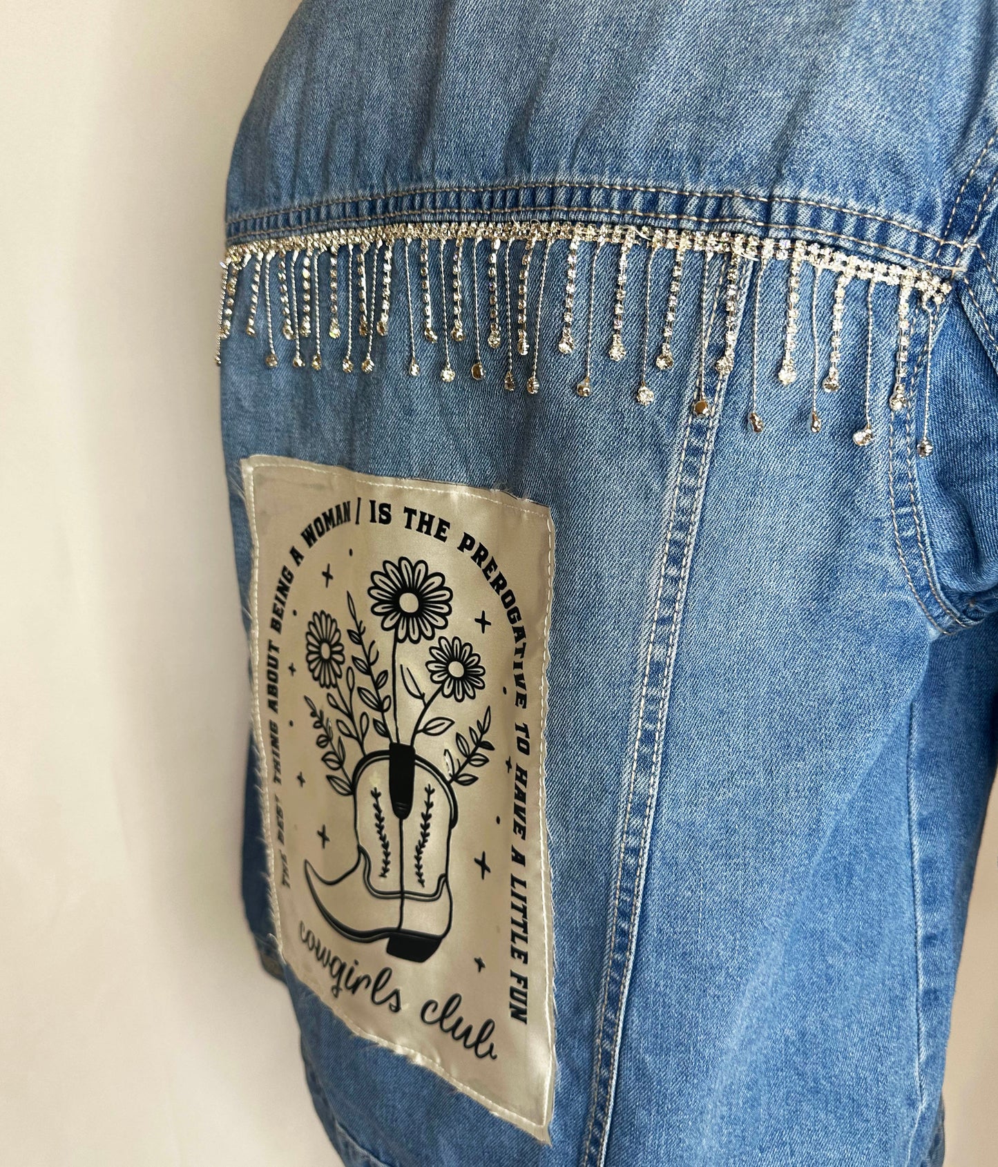 "Cowgirl Club" Womens Medium Denim Jacket featuring rhinestone detailing and satin patch "The thing about being a woman is the perogative to have a little fun"