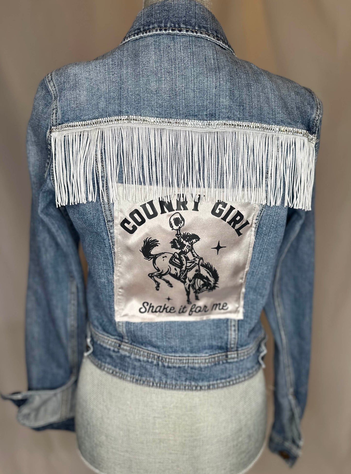 White Fringe "Country girl shake it for me" Womens Denim Jacket Back Side with satin detailing.