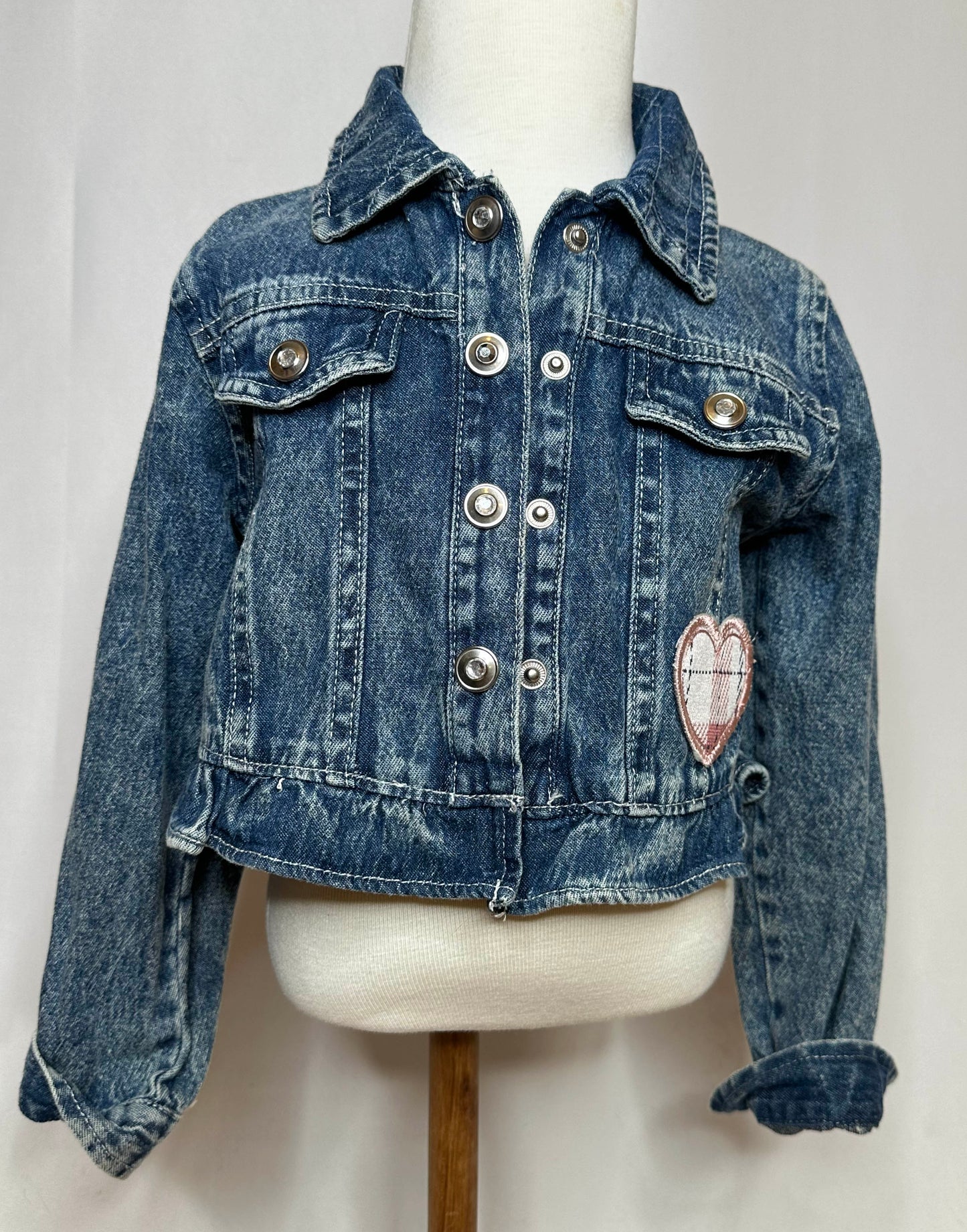 "Yee Haw" Pink Fringe Kids Denim Jacket Front Side featuring button up, double button pockets, seamless stitching and pink heart on left pocket.