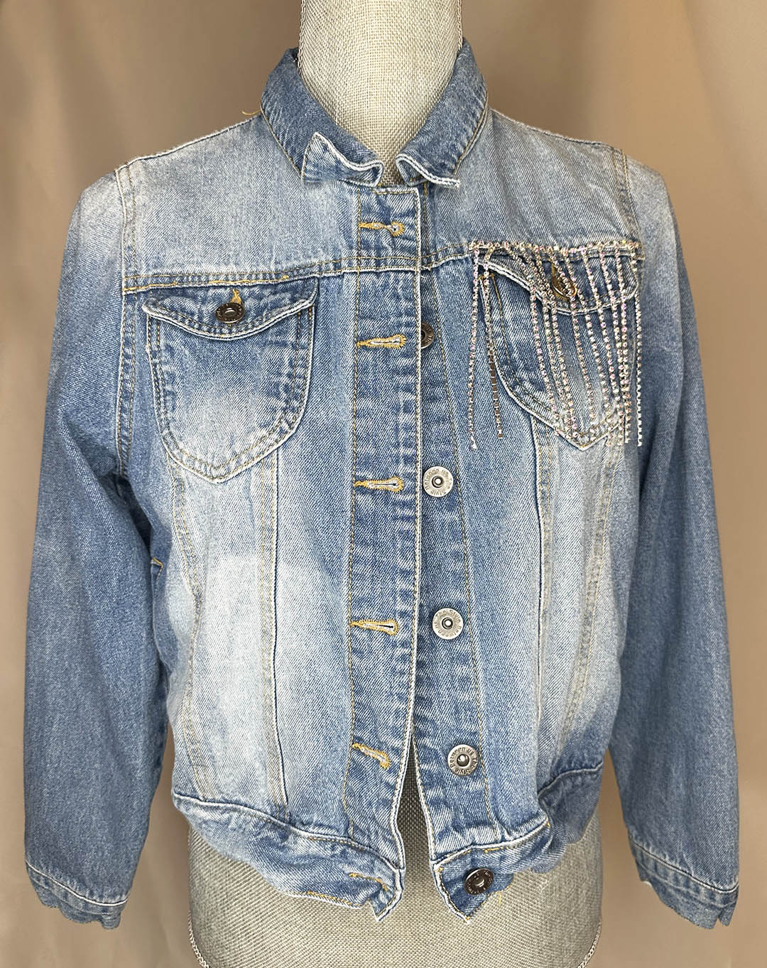 "Coors Rodeo" Women's Fringe Denim Jacket Front Side featuring rhinestone waterfall detailing above left side pocket.