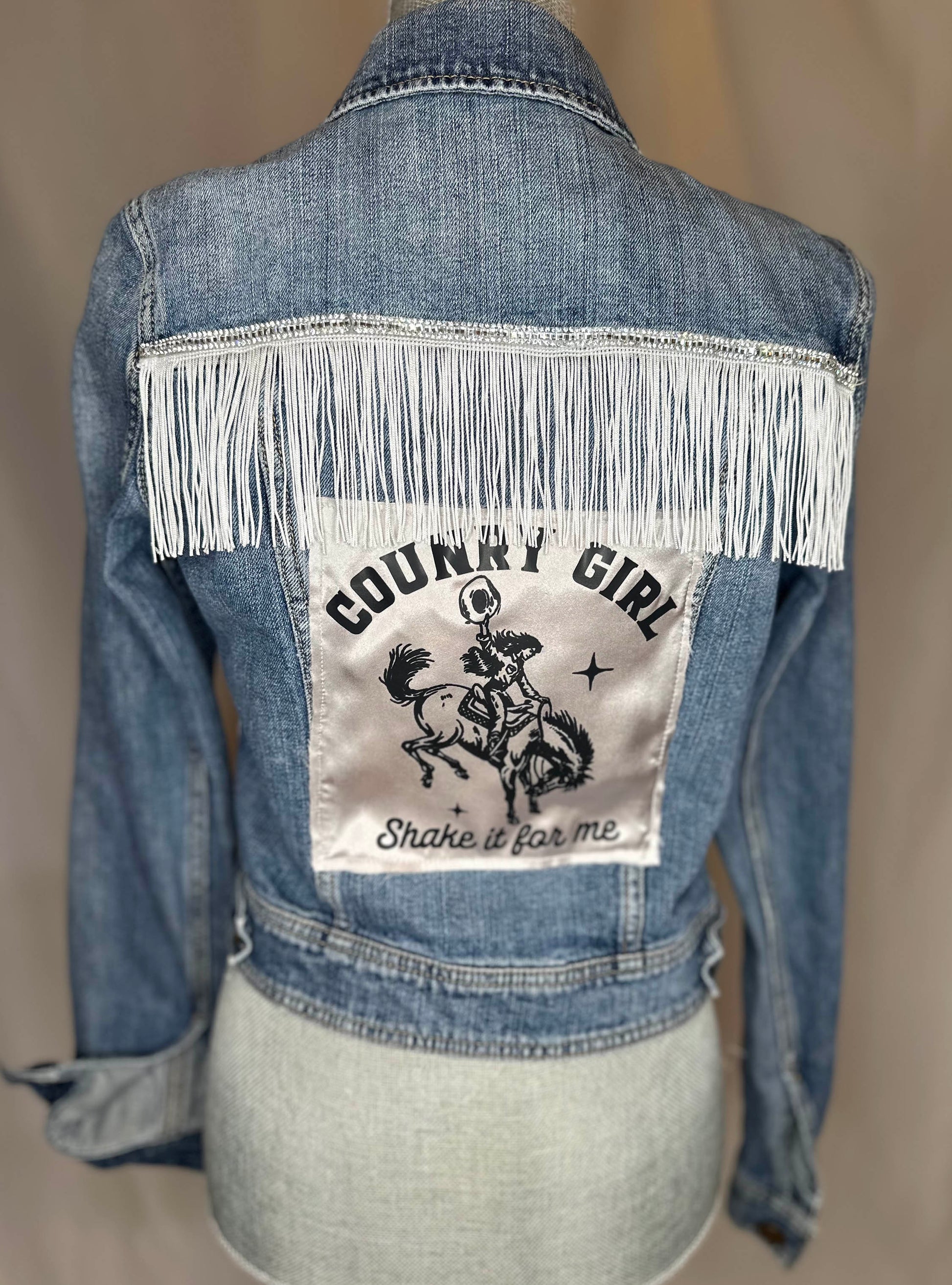 White Fringe "Country girl shake it for me"  Womens Denim Jacket Back Side with satin detailing.