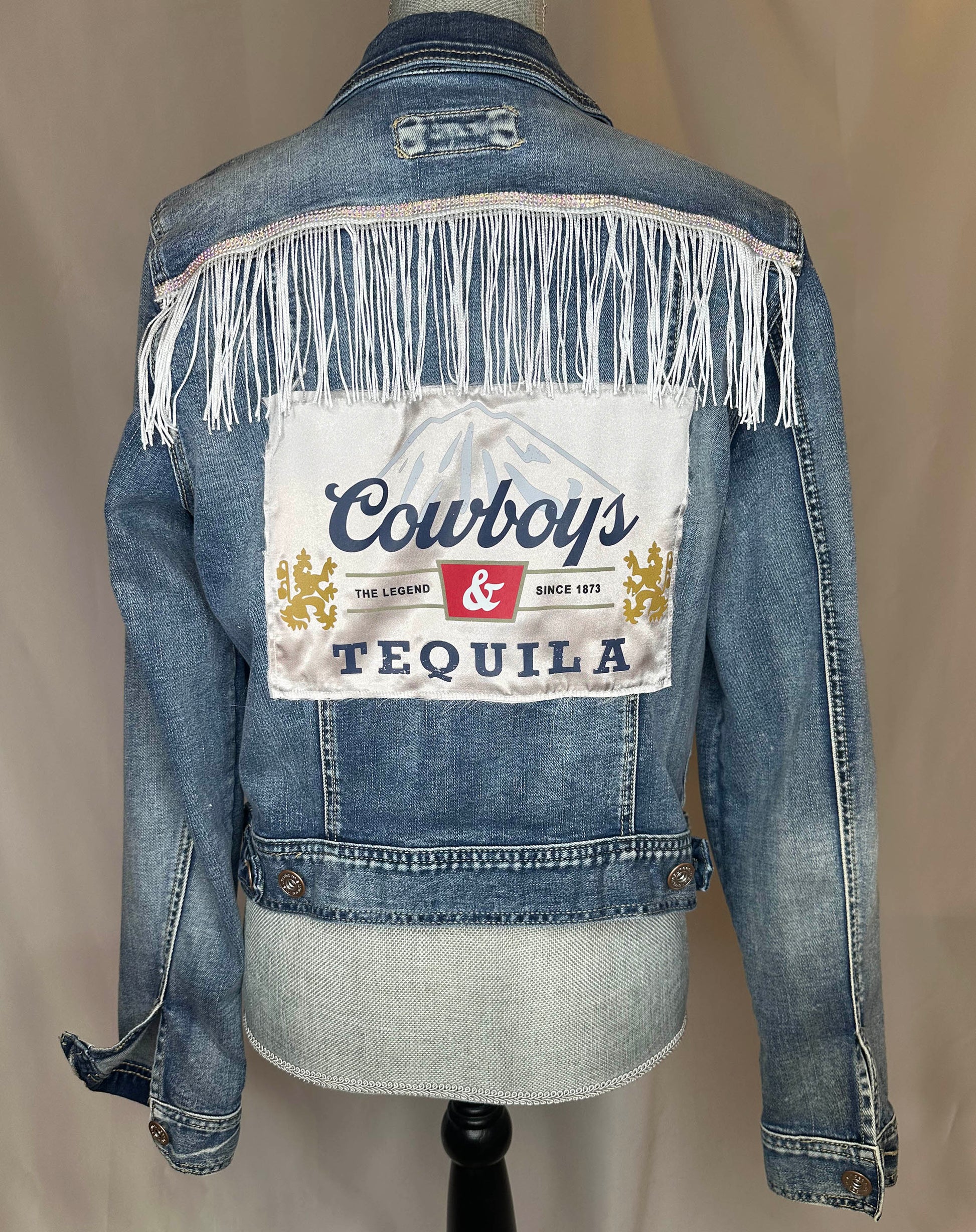 White_Fringe_Cowboys_Tequila_Womens_Denim_Jacket_Side with rhinestone and white fringe detailing on back side